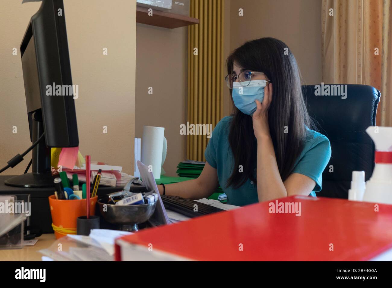 Employee works in the office with the mask to prevent infection during the virus quarantine. Stock Photo