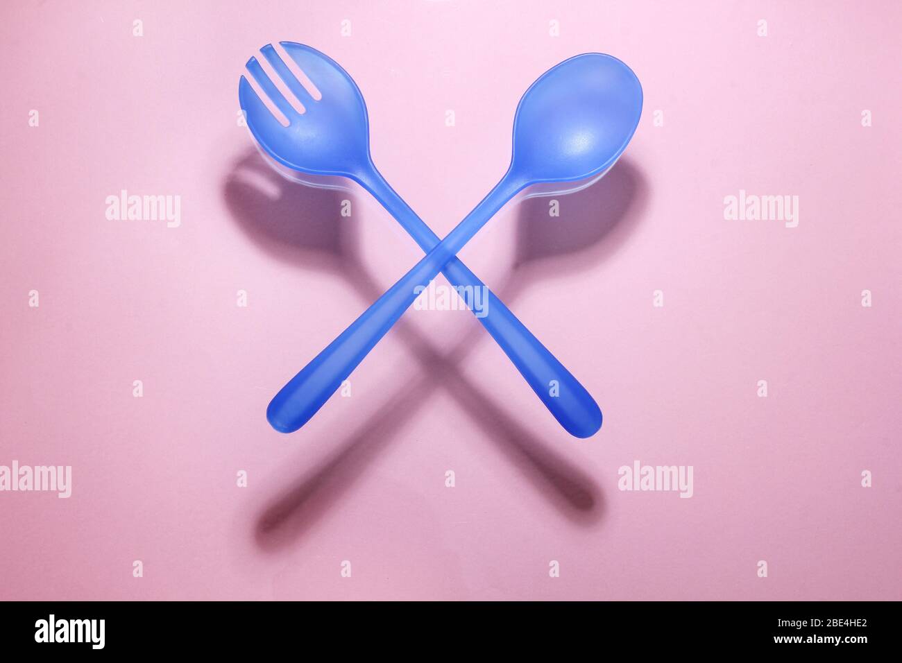 Plastic Fork and Spoon on Pink Background Stock Photo