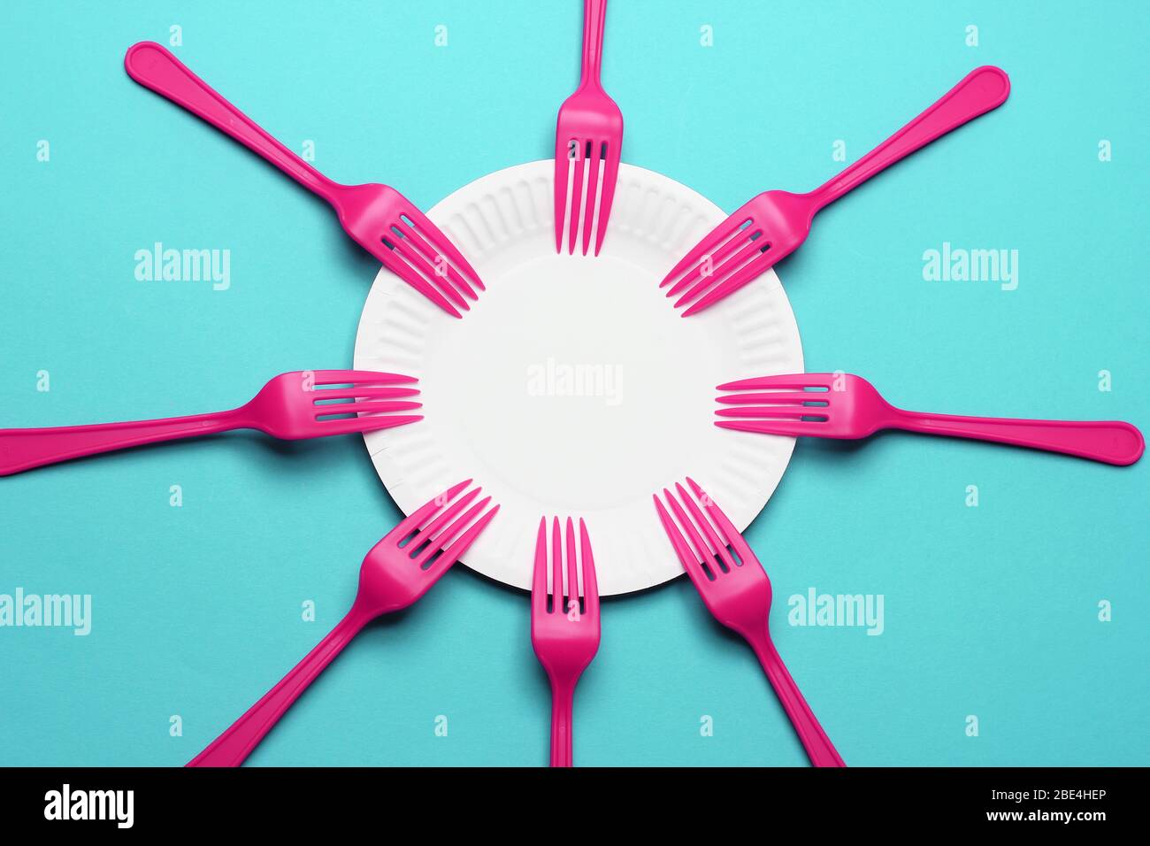 Paper Plate and Plastic Forks on Blue Background Stock Photo