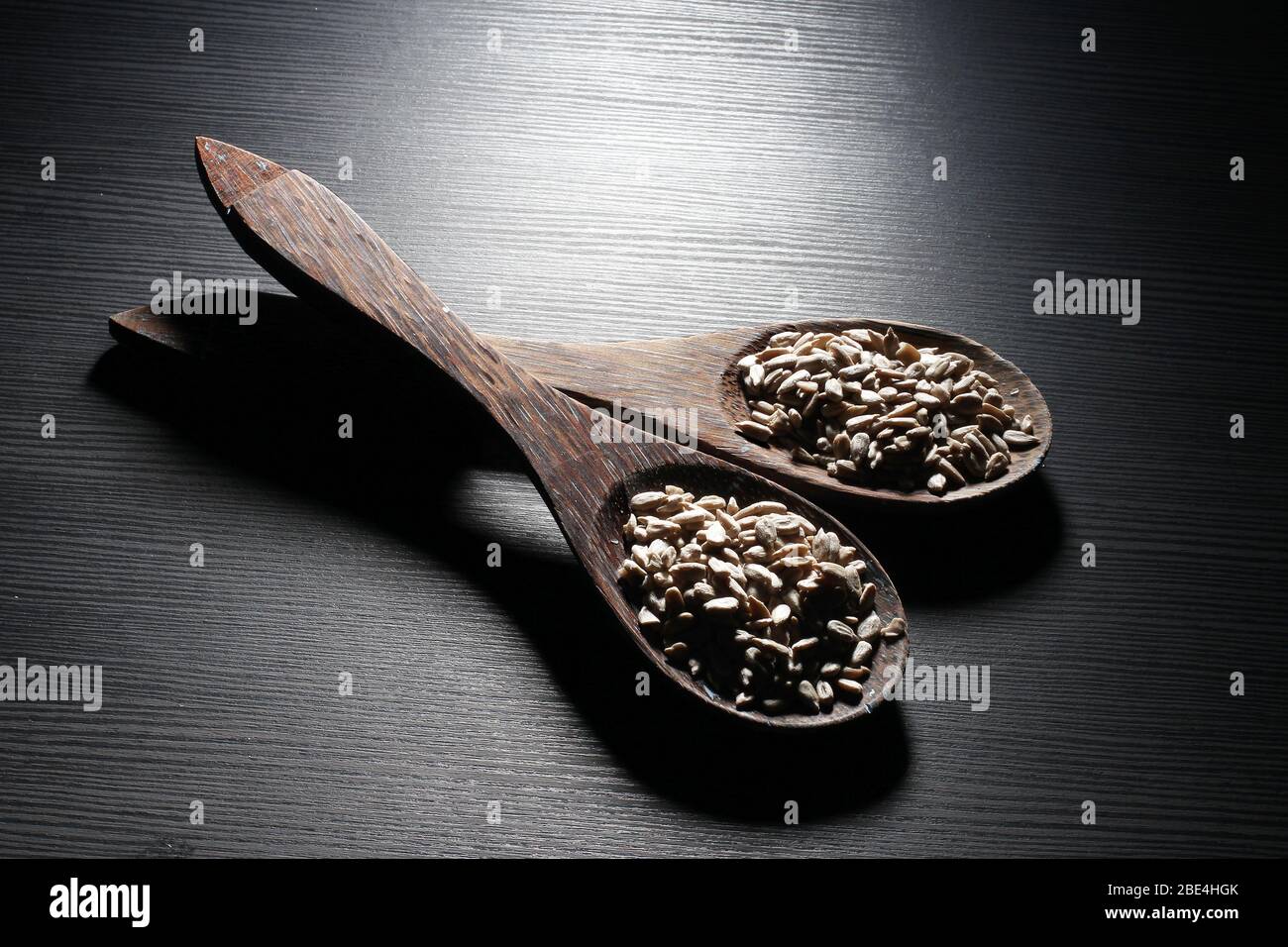 Wooden Spoons with Sunflower Seeds on Wooden Background Stock Photo