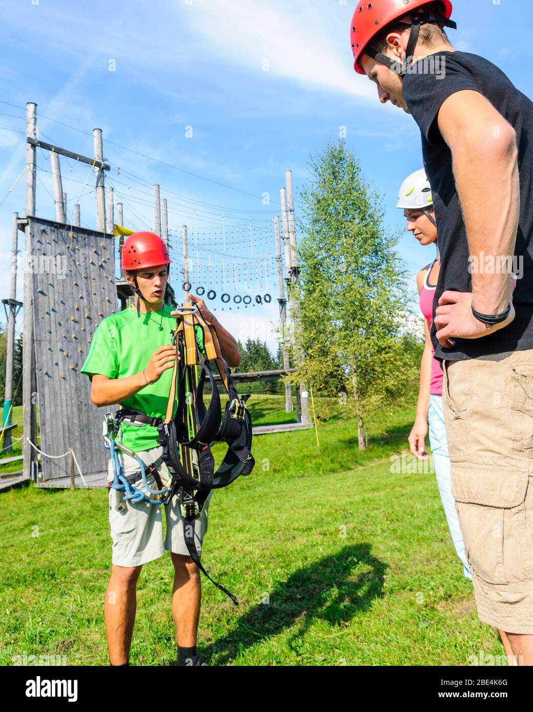 Preparing for climbing exercises in high ropes park with an instructor