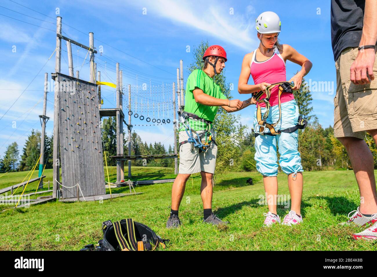 Preparing for climbing exercises in high ropes park with an instructor