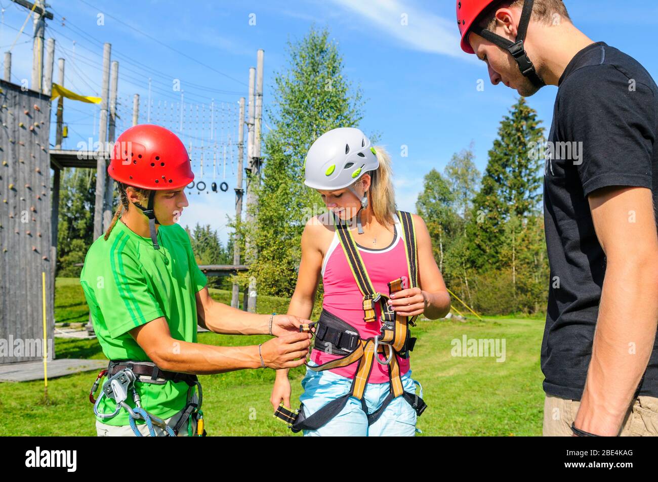Preparing for climbing exercises in high ropes park with an instructor