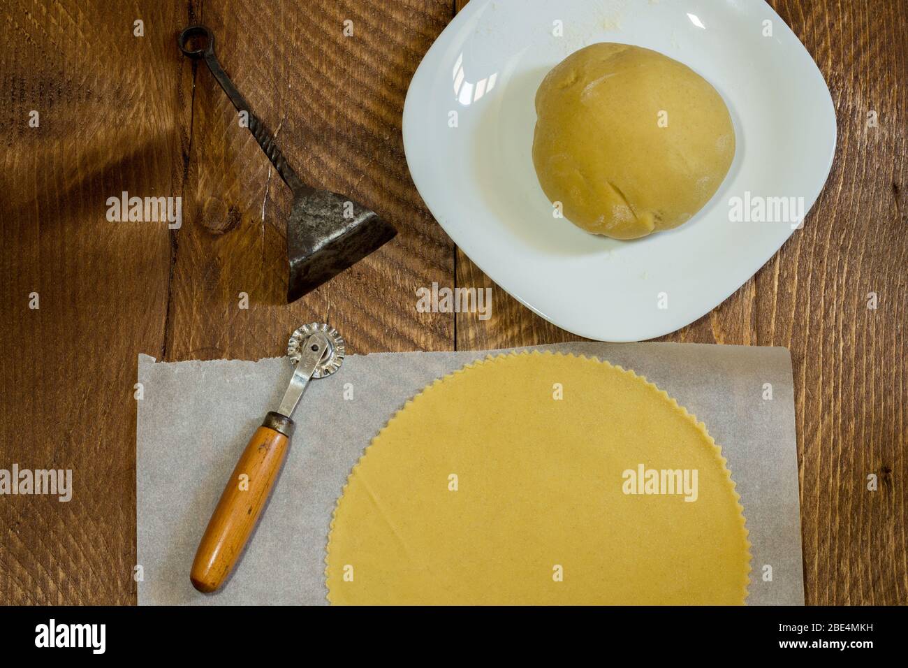 The image shows the pastry used for panzerotti filled with cheese and egg, a typical product of the Easter tradition of Campania. On wooden background Stock Photo