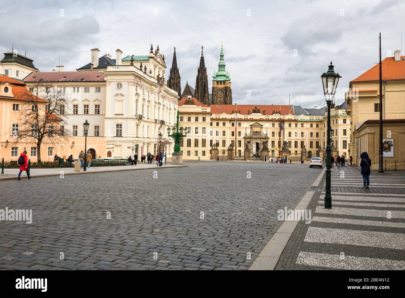 PRAGUE, CZECH REPUBLIC - MARCH 10, 2020: Hradcanske Square, the Archbishop Palace and Prague Castle. People in the square Stock Photo