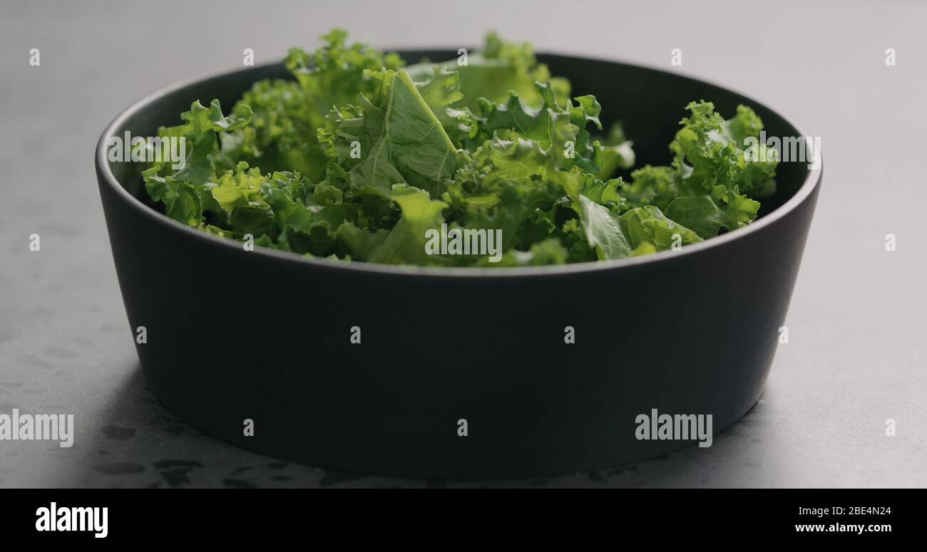 kale in black bowl on concrete surface Stock Photo