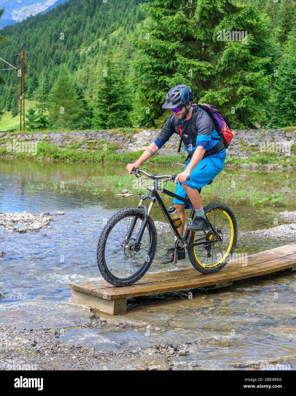 Young cyclist crossing small brook Stock Photo Alamy
