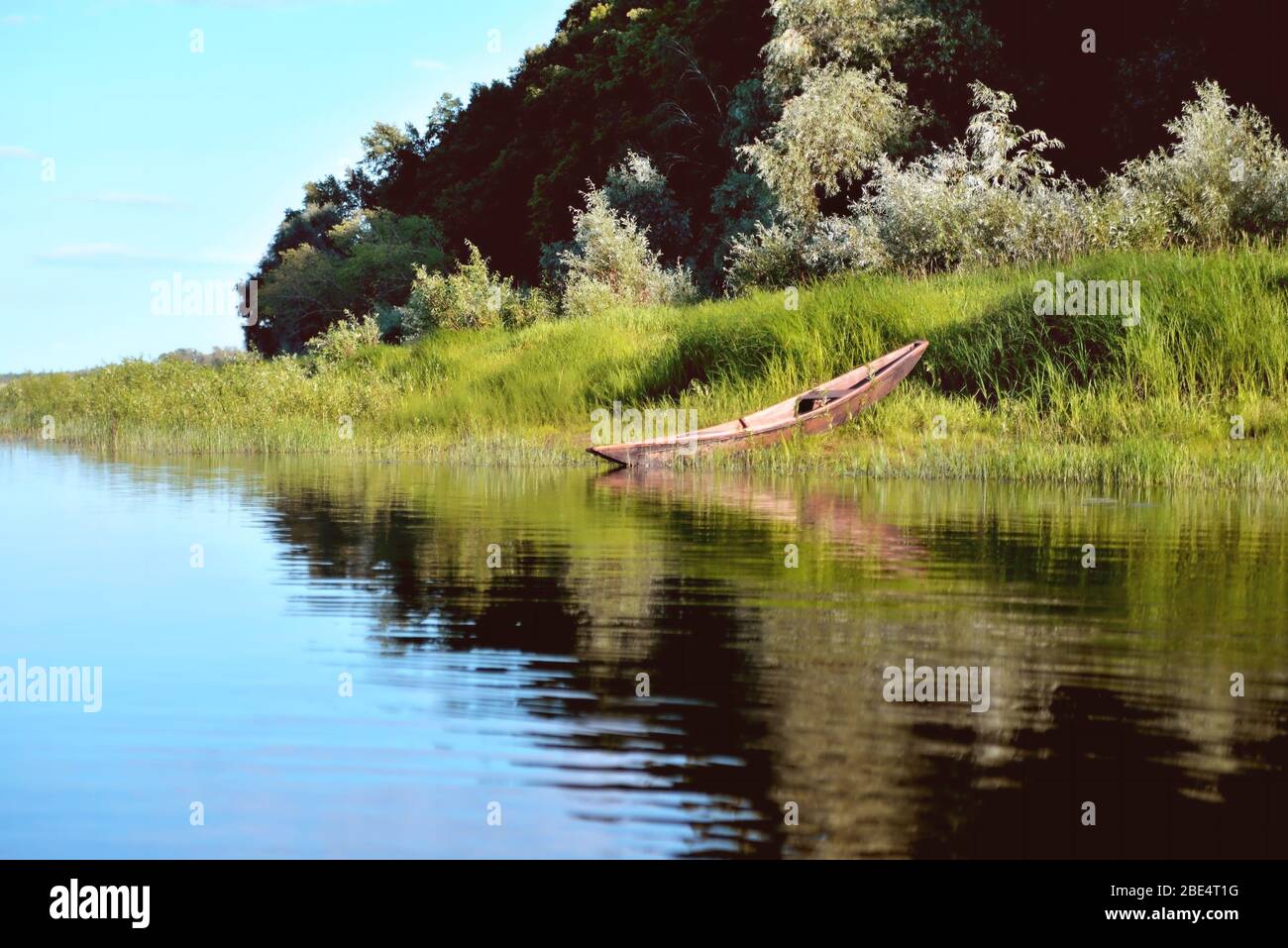 old wooden boat on the river bank close up against the background of ...