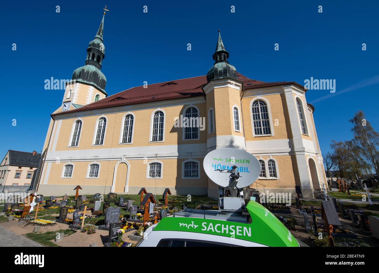 Crostwitz, Germany. 12th Apr, 2020. An audio mobile of the MDR with  satellite dish is standing in front of the Catholic Church "St. Simon and  Juda" during the transmission of the Easter