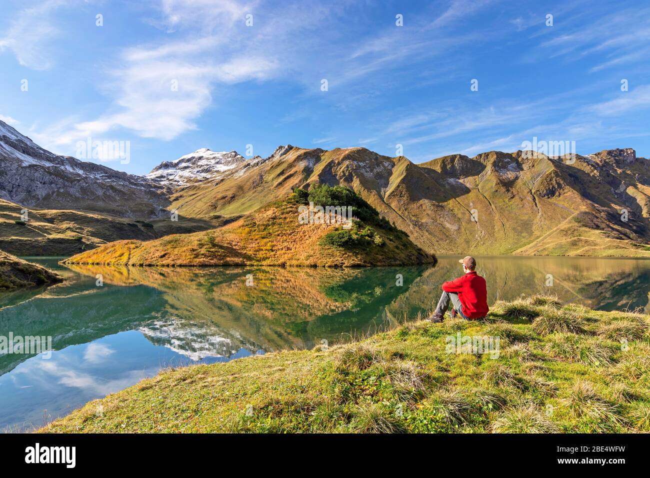 Man sitting at a mountain lake. Allgäu Alps, Bavaria, Germany Stock Photo