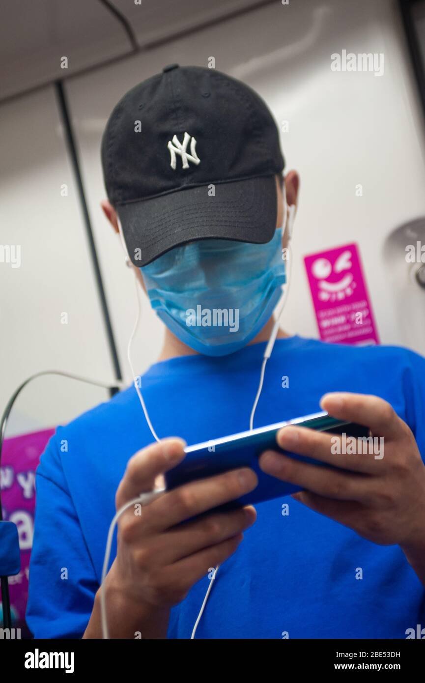 28.02.2020, Singapore, Republic of Singapore, Asia - A man wears a protective face mask on a subway to prevent an infection with the coronavirus. Stock Photo