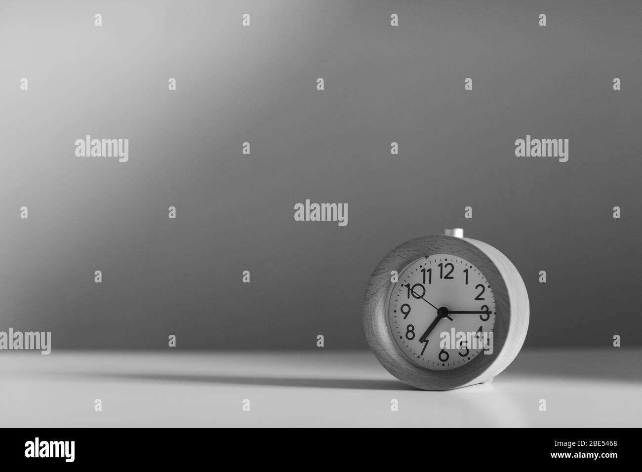 Alarm clock on white table background monochrome Stock Photo