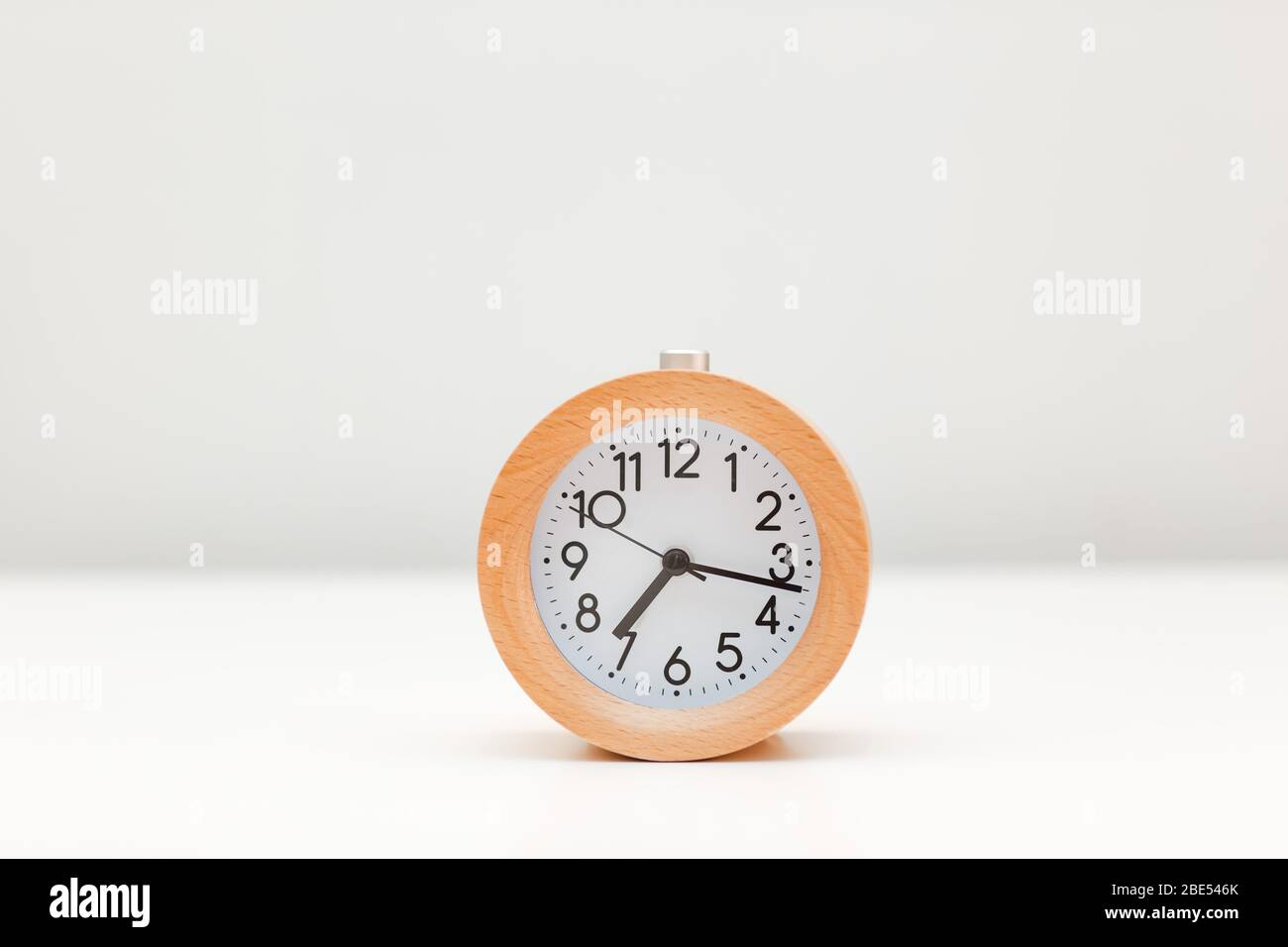 Alarm clock on white table background Stock Photo - Alamy