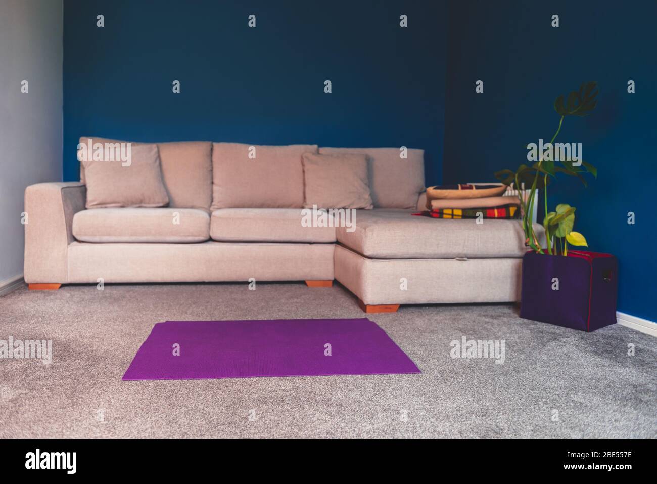 Preparation for online yoga during self isolation. . Yoga mat at the living room, no equipment workout, meditation tips for beginners, stay home and stay healthy concept Stock Photo