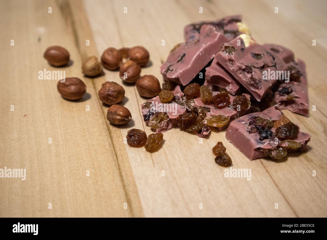 https://c8.alamy.com/comp/2BE55CE/pink-chocolate-chocolate-with-nuts-raisins-and-cranberries-2BE55CE.jpg