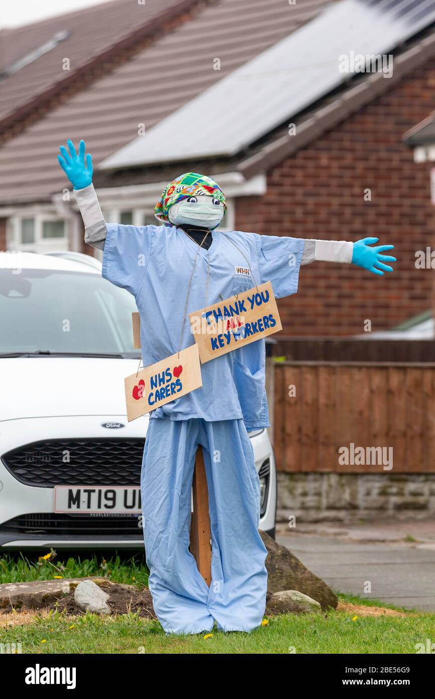 12 April 2020 - Warrington, Cheshire, England   A member of the public uses a 'Scarecrow' dressed in Scrubs to thank the keyworkers showing their gratitude toward all Keyworkers by dressing a model of a surgeon in scrubs and displaying thank you boards Credit: John Hopkins/Alamy Live News Stock Photo