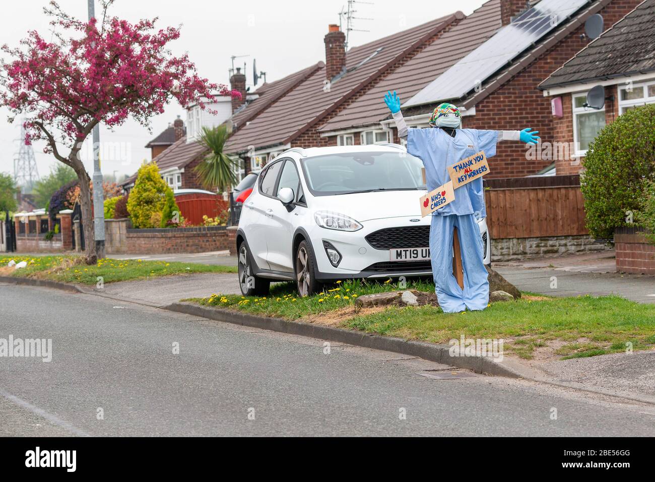 12 April 2020 - Warrington, Cheshire, England   A member of the public uses a 'Scarecrow' dressed in Scrubs to thank the keyworkers showing their gratitude toward all Keyworkers by dressing a model of a surgeon in scrubs and displaying thank you boards Credit: John Hopkins/Alamy Live News Stock Photo