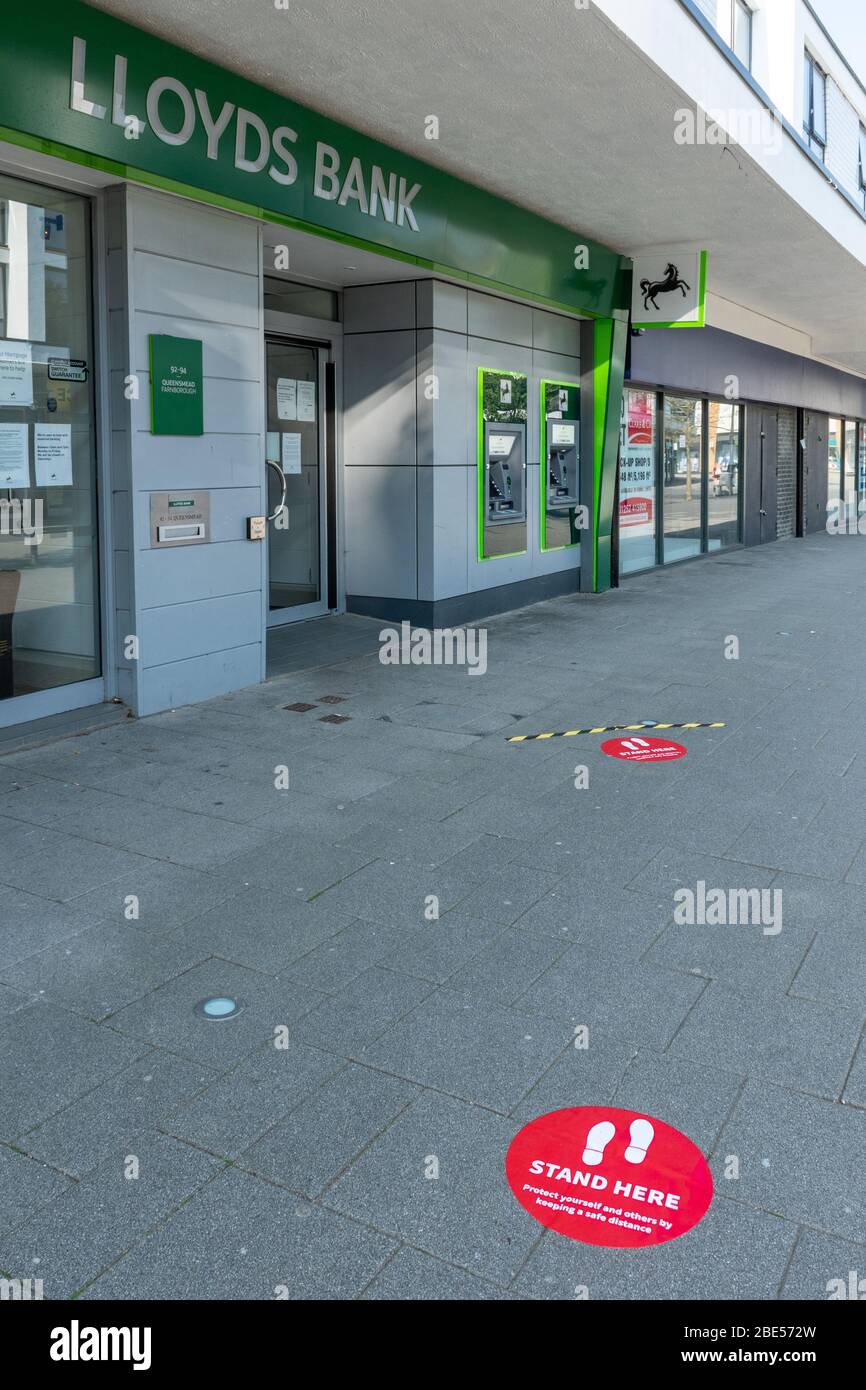 10 April 2020. During the 2020 coronavirus Covid-19 pandemic, a lockdown is in place in the UK, and people are only allowing to go out for specific reasons. In Farnborough town centre, Hampshire, the Lloyds Bank branch has put markers outside on the pavement two metres apart to help people observe safe social distancing when queueing to enter the bank. Stock Photo