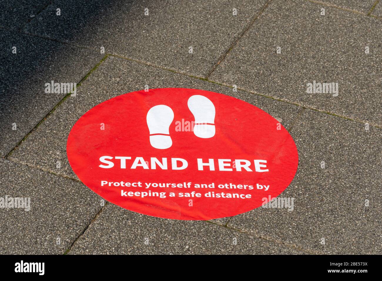 10 April 2020. During the 2020 coronavirus Covid-19 pandemic, a lockdown is in place in the UK, and people are only allowing to go out for specific reasons. In many town centres, banks and businesses have put markers outside on the pavement two metres apart to help people observe safe social distancing when queueing to enter the bank. Stock Photo