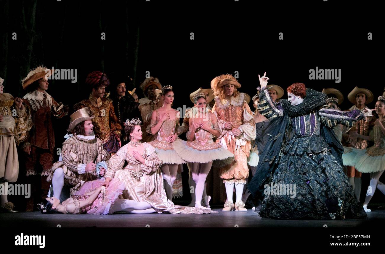 Carabosse (far right) places a curse upon Aurora (far left, lying on stage) - front, l-r: Tamara Rojo (Princess Aurora), Antony Dowson (King Florestan XXIV), Jane Haworth (His Queen), James Streeter (Carabosse) in THE SLEEPING BEAUTY presented by English National Ballet in 2012 music: Tchaikovsky choreography: MacMillan after Petipa set design: Peter Farmer costumes: Nicholas Georgiadis Stock Photo