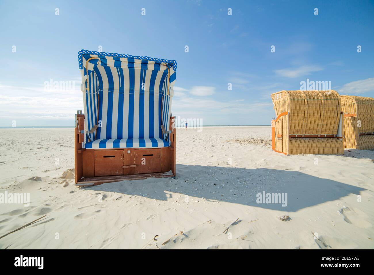 Blue and white striped wooden beach chair or bench on white sandy ...