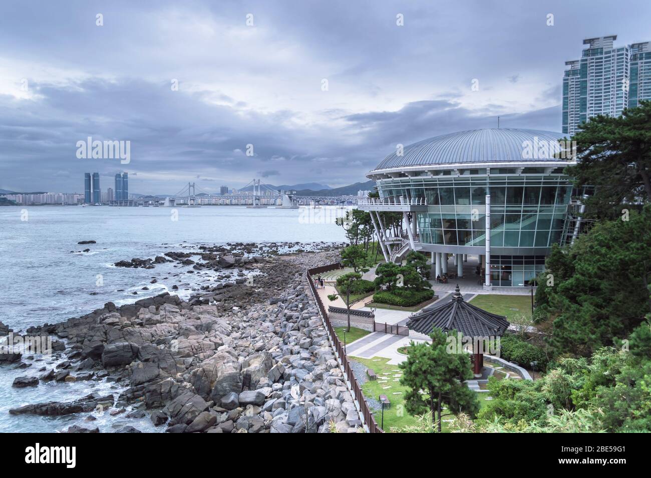 Busan, South Korea, September 12, 2019: Nurimaru APEC House on gloomy day with cityscape of Busan and Gwangandaegyo Bridge on background Stock Photo