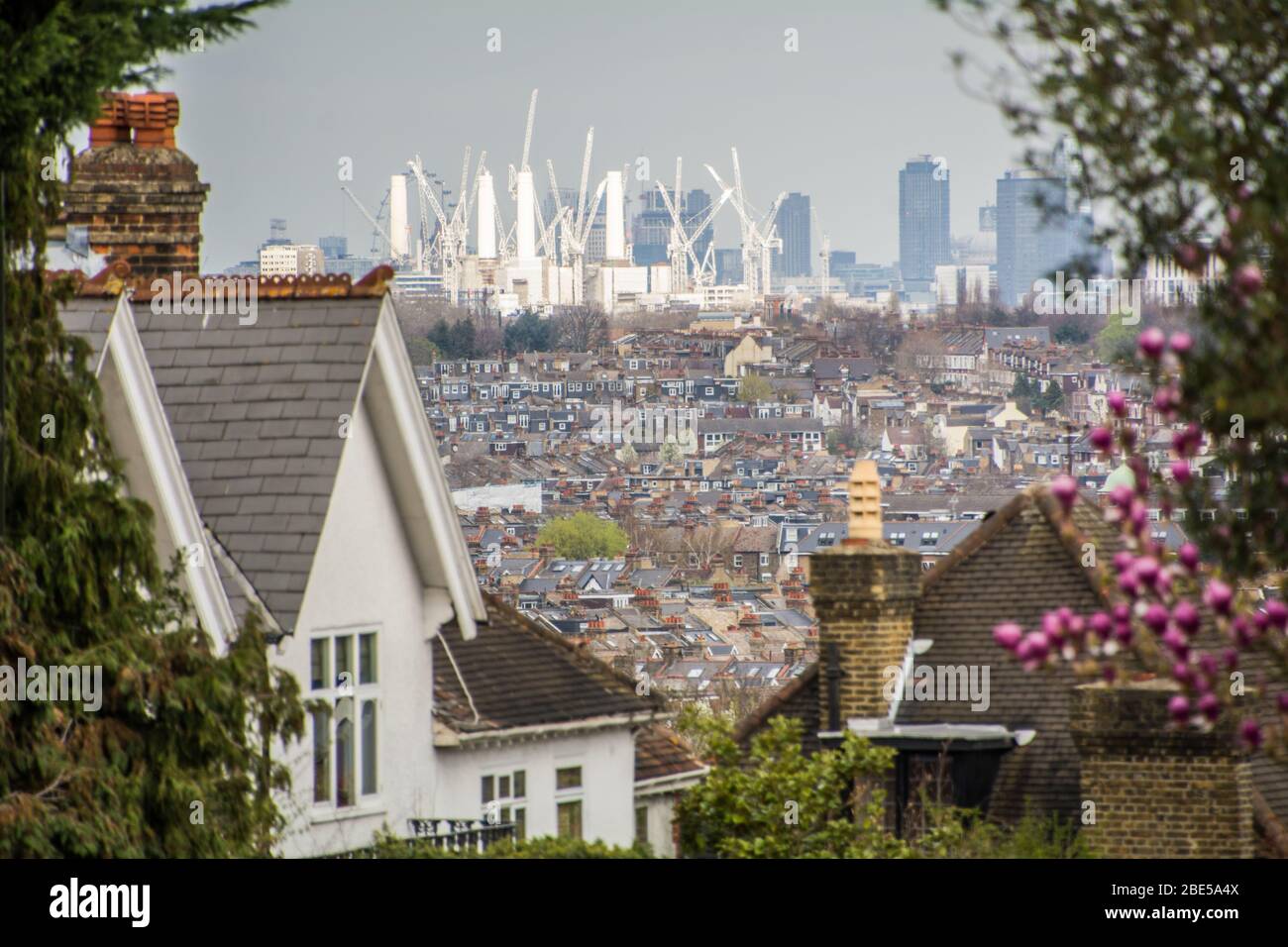 Street of house rooftops in Wimbledon with view of the City of London