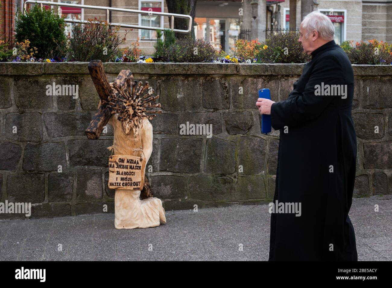 A priest stands in front of a sculpture of Jesus carrying a cross during Easter amid coronavirus outbreak in Sopot.Poland has confirmed 6,356 coronavirus cases, 208 deaths and 375 recovered cases. Stock Photo