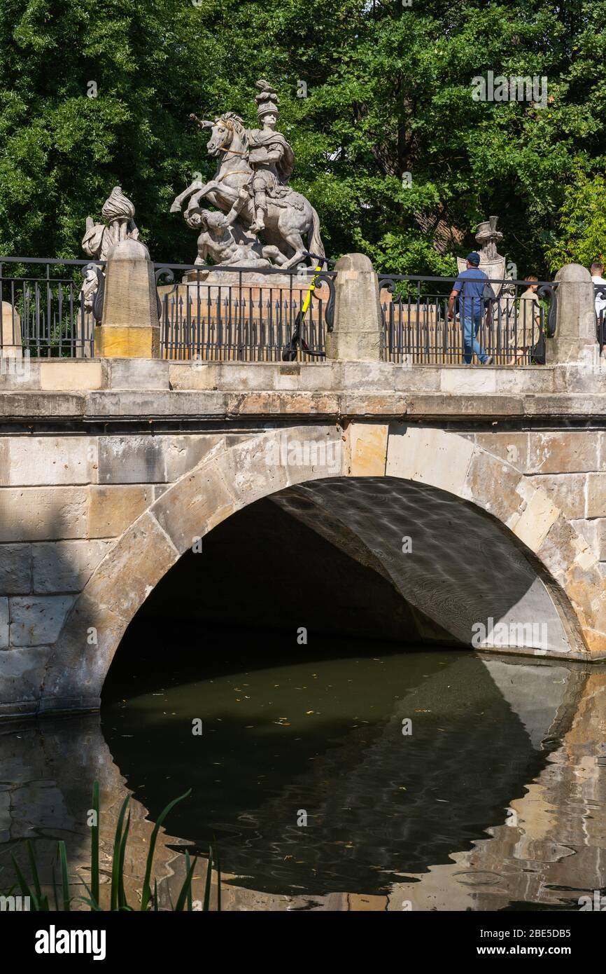 Arched bridge over the lake in Lazienki Park and monument to King Jan III Sobieski in Warsaw, Poland Stock Photo