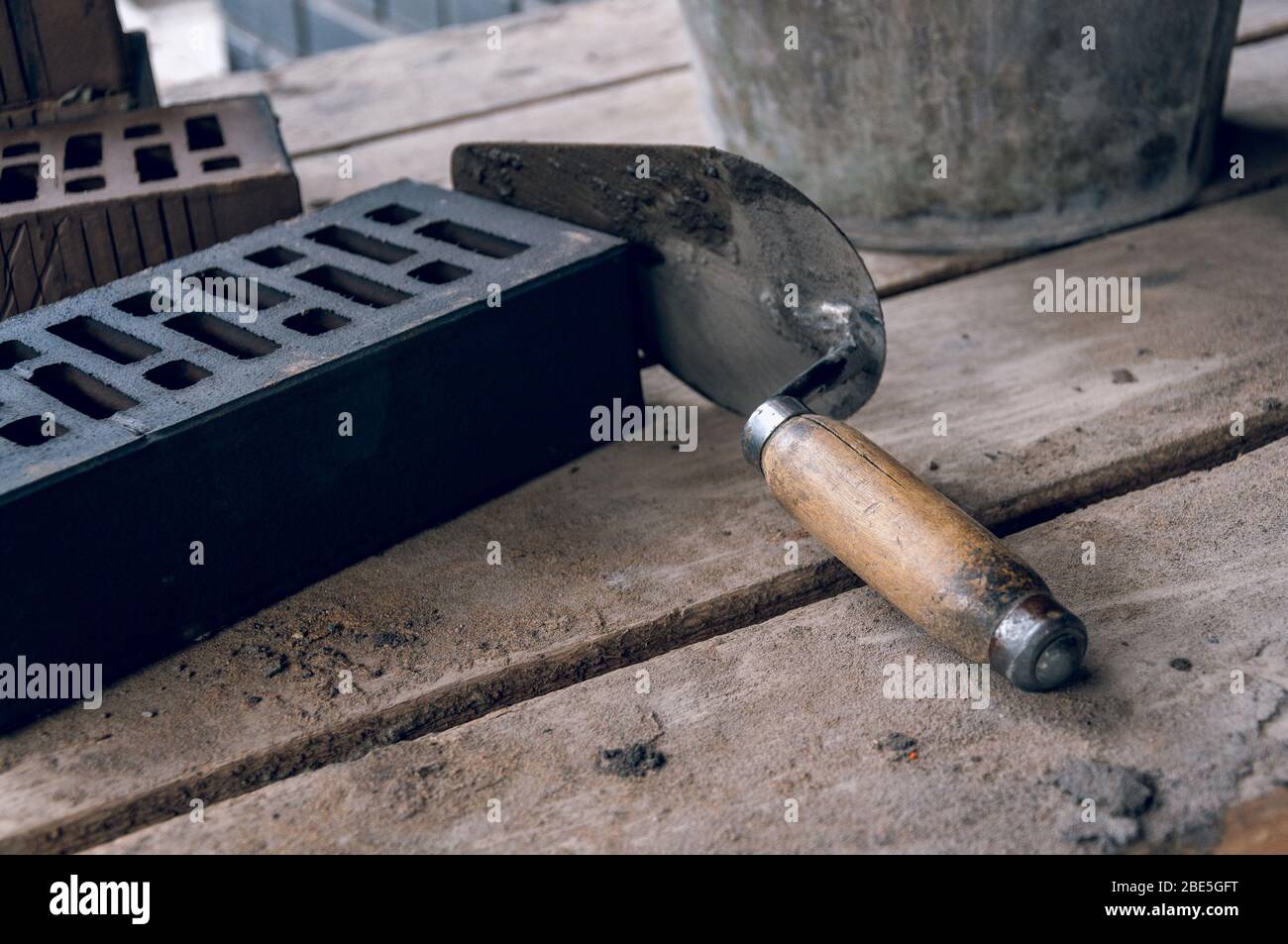 A mason tool by a stern plan in the workplace. Trowel for bricklaying