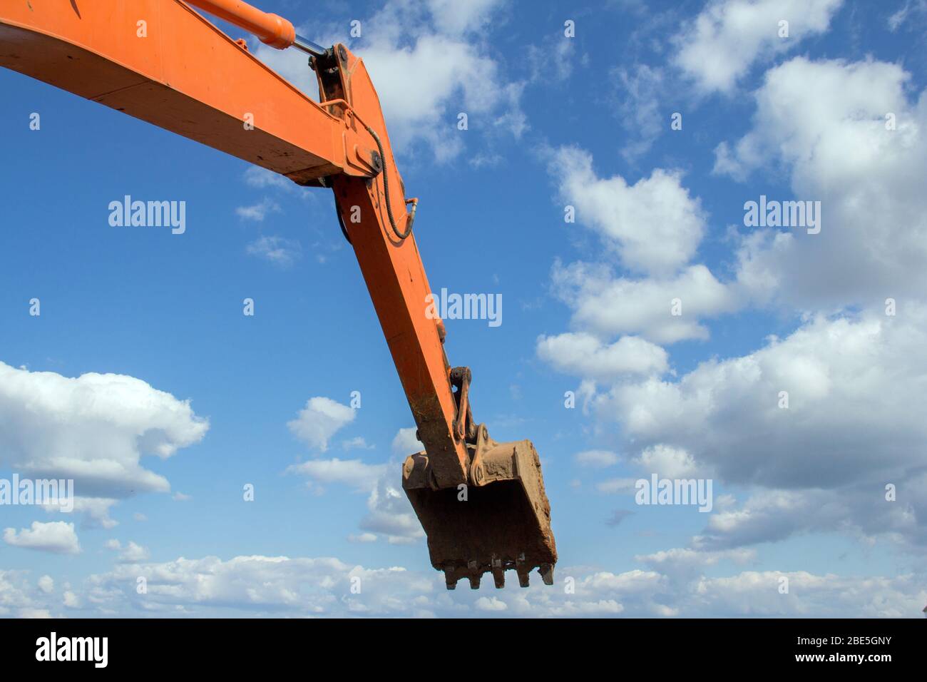 Excavator hydraulic bucket for loading materials against the sky. Stock Photo