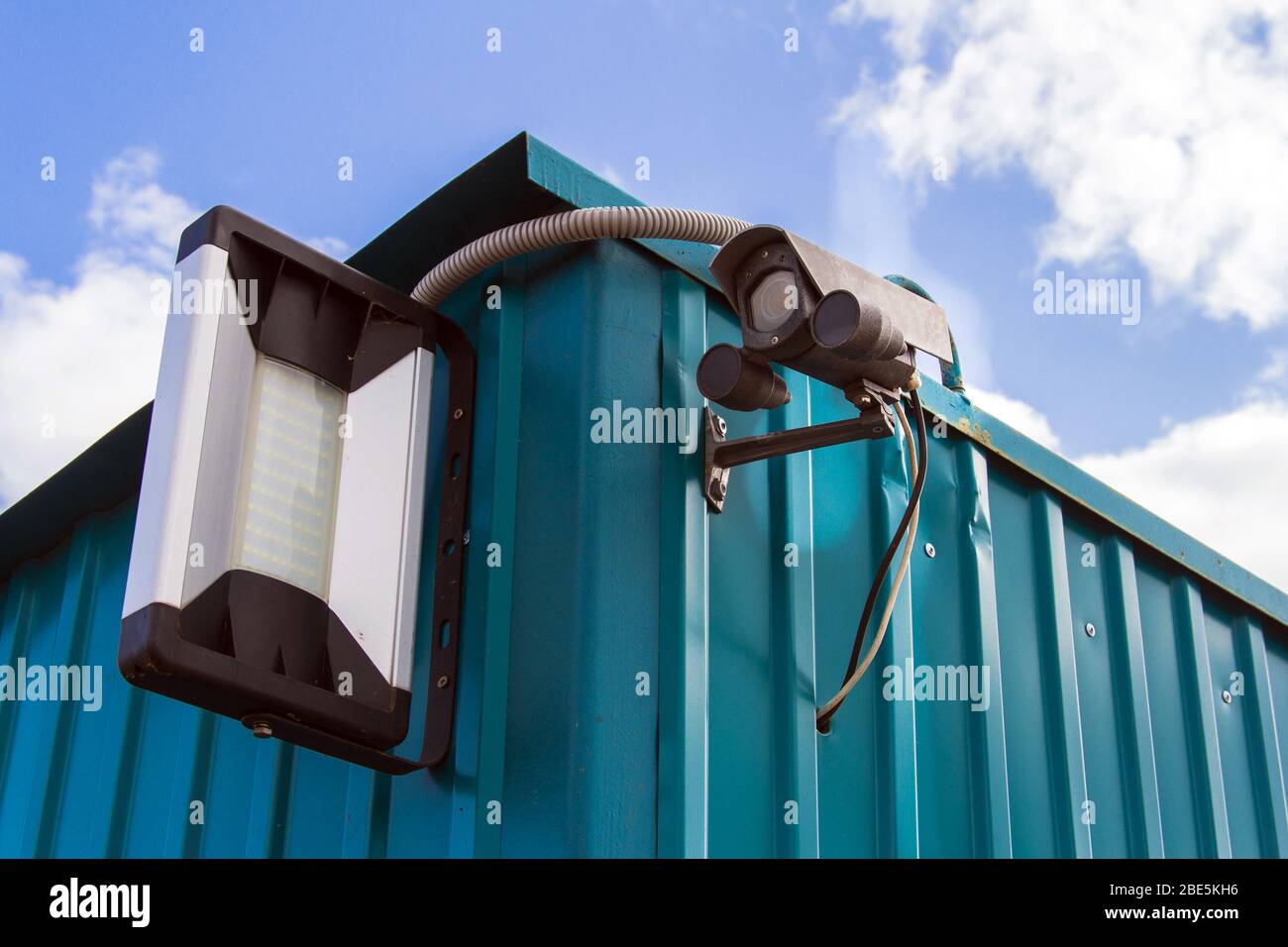 Security Camera on a blue sky background. Surveillance camera for
