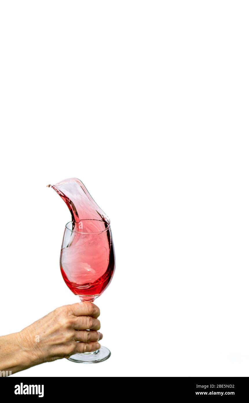Wine splashing out of wine glass Stock Photo