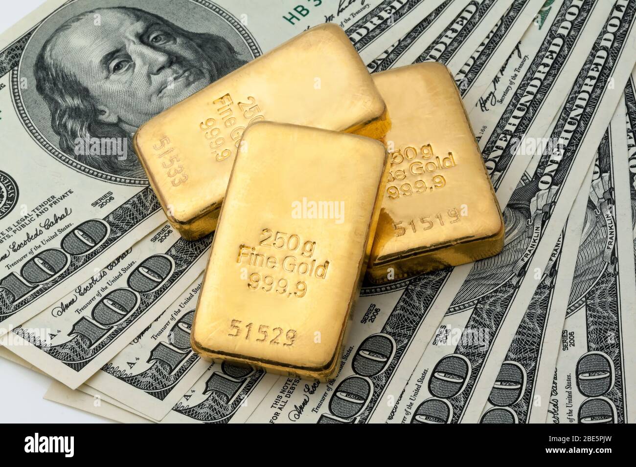Gold als Wertanlage in Goldbarren und Muenzen, 100 US-Dollar Banknoten im  Hintergrund Stock Photo - Alamy