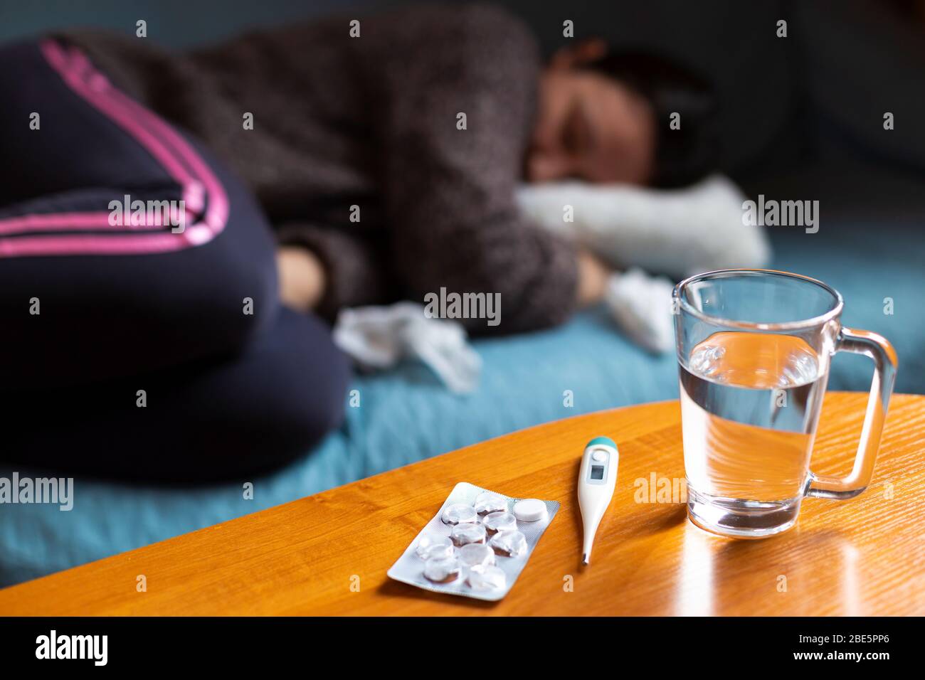 Woman feeling sick. Sick woman feeling ill, cramps lying on sofa Stock Photo
