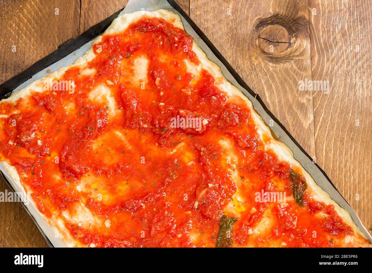 Vegan tomato pizza pan without cheese ready to bake in the home wood oven Stock Photo