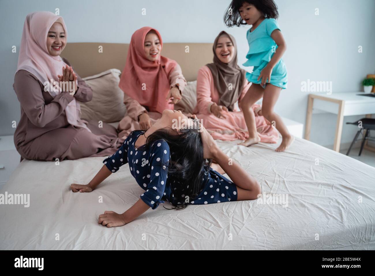 Three asian mother enjoy playing with her daughter in the bedroom when government attention for still stay at home Stock Photo