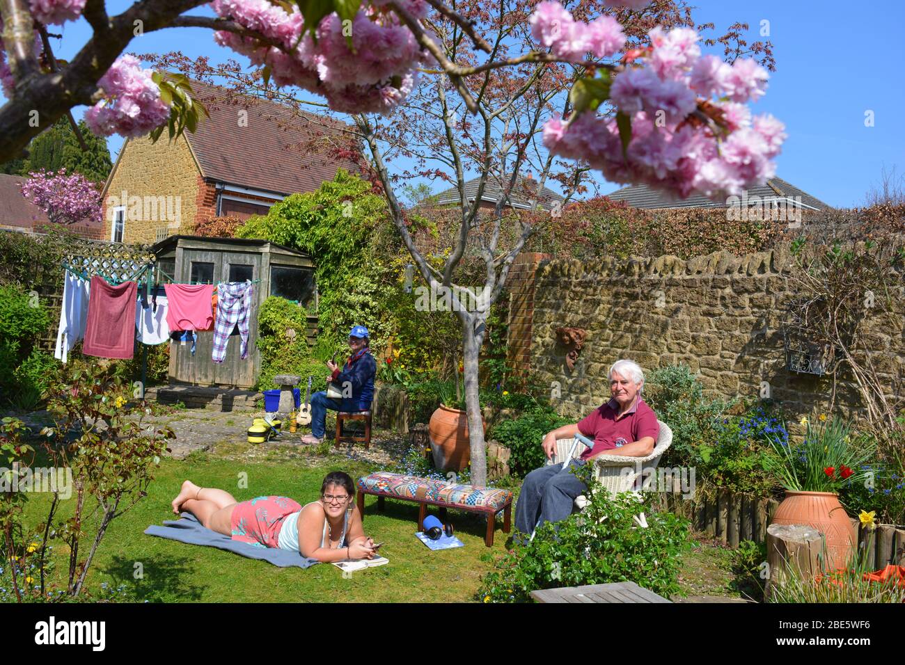Family group enjoying the garden in the Springtime, Stay home, Stay safe, during the Covid-19 pandemic Stock Photo