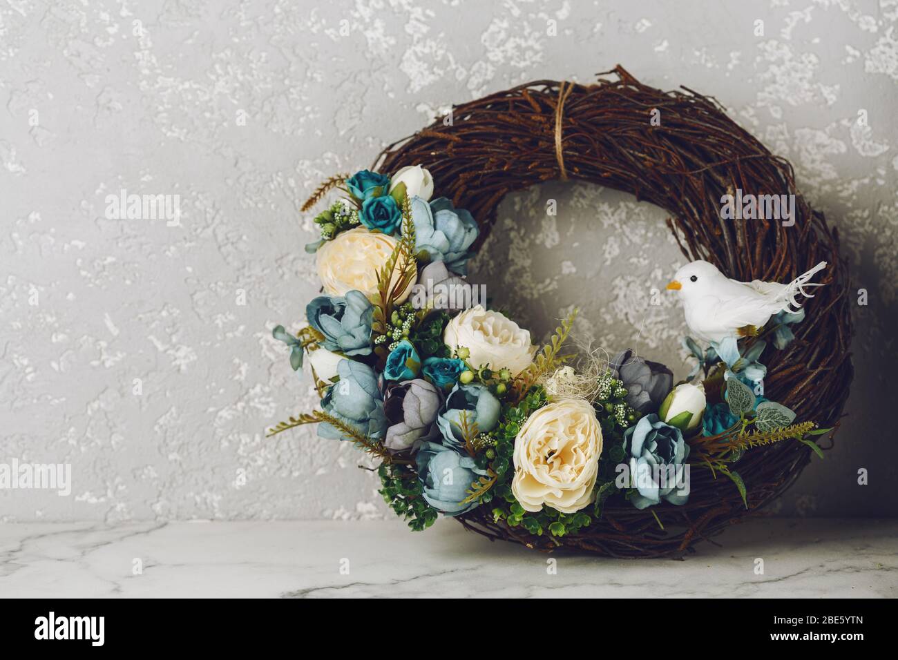 Easter wreath with eggs, blue flowers and little bird. Holiday concept. Copy space Stock Photo