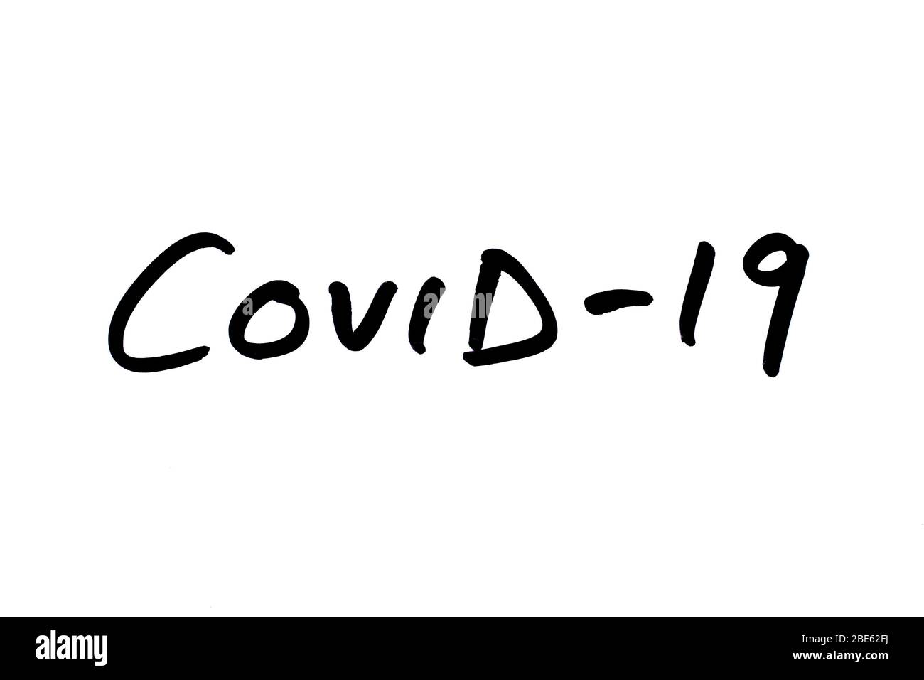 COVID-19 handwritten on a white background. Stock Photo
