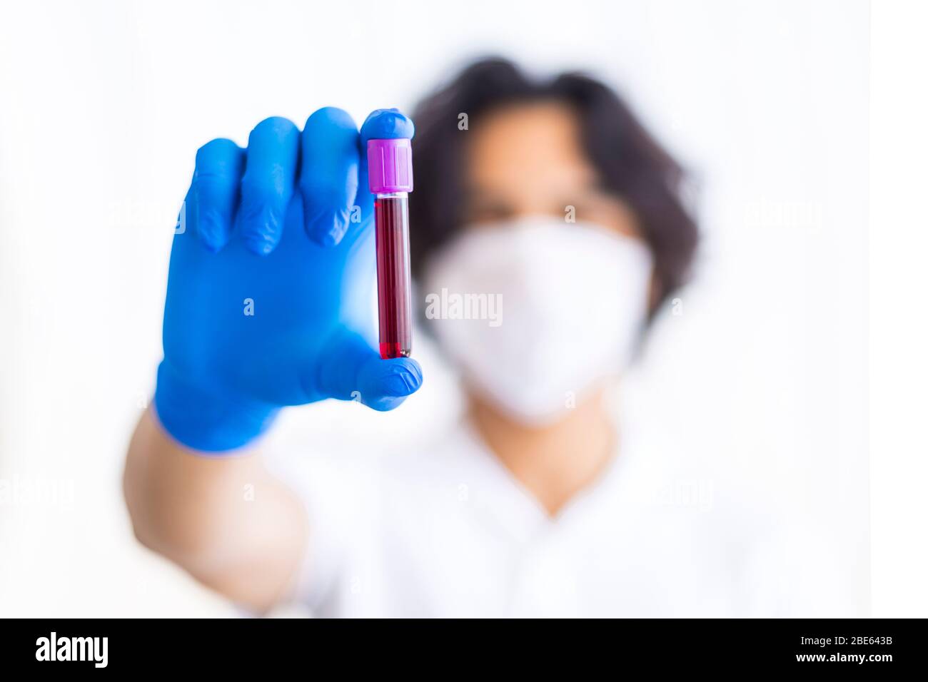 A gloved junior doctor holding a positive blood test result for coronavirus in Turkey Stock Photo