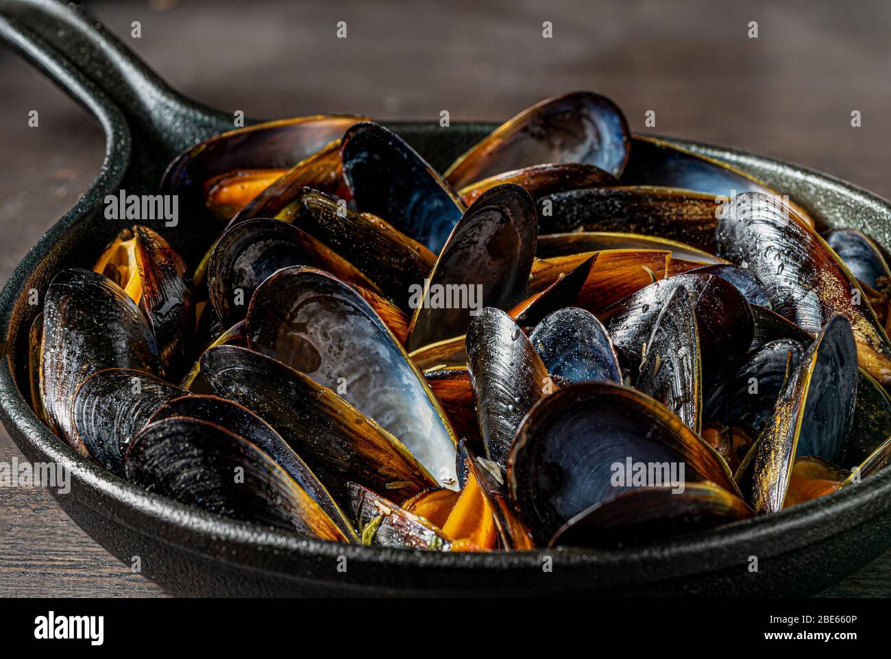 Steamed mussels in cast iron pot. Stock Photo
