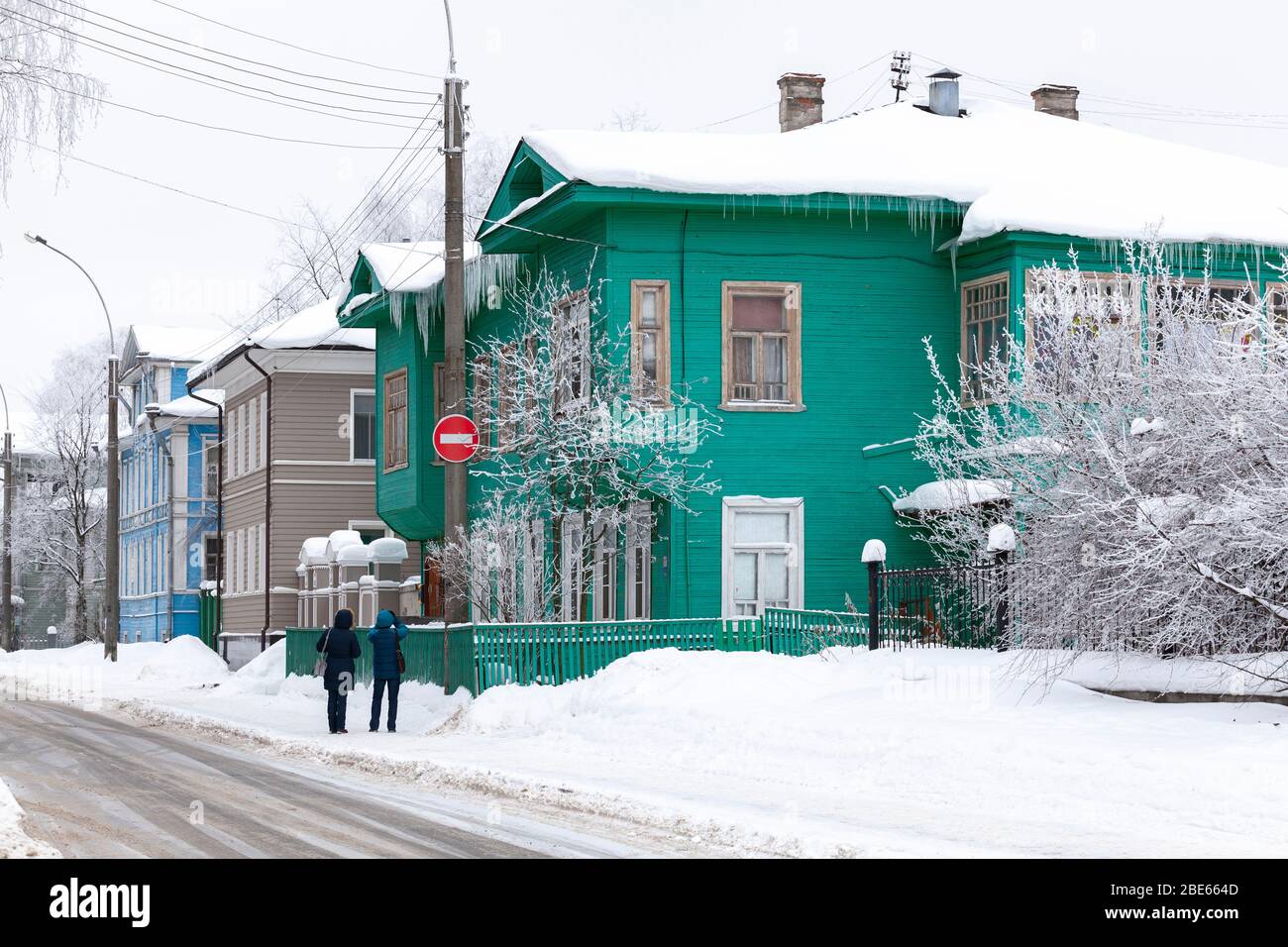 Vologda, Russia - February 3, 2019: Street view of Vologda at winter day, tourists take photos of old green wooden house Stock Photo