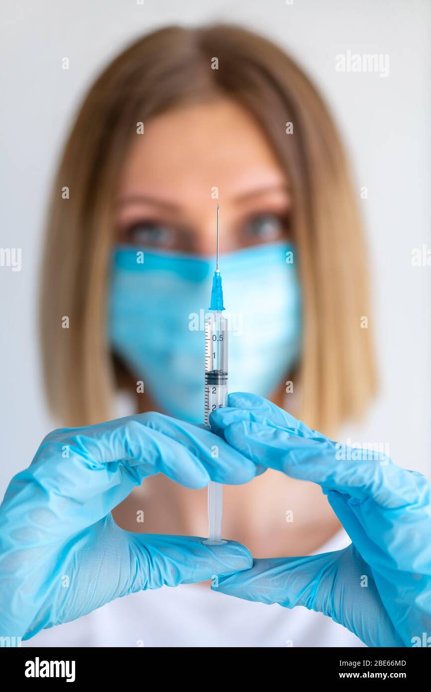 Syringe for injection in nurse hand. Medical glass vial for vaccination. Science equipment