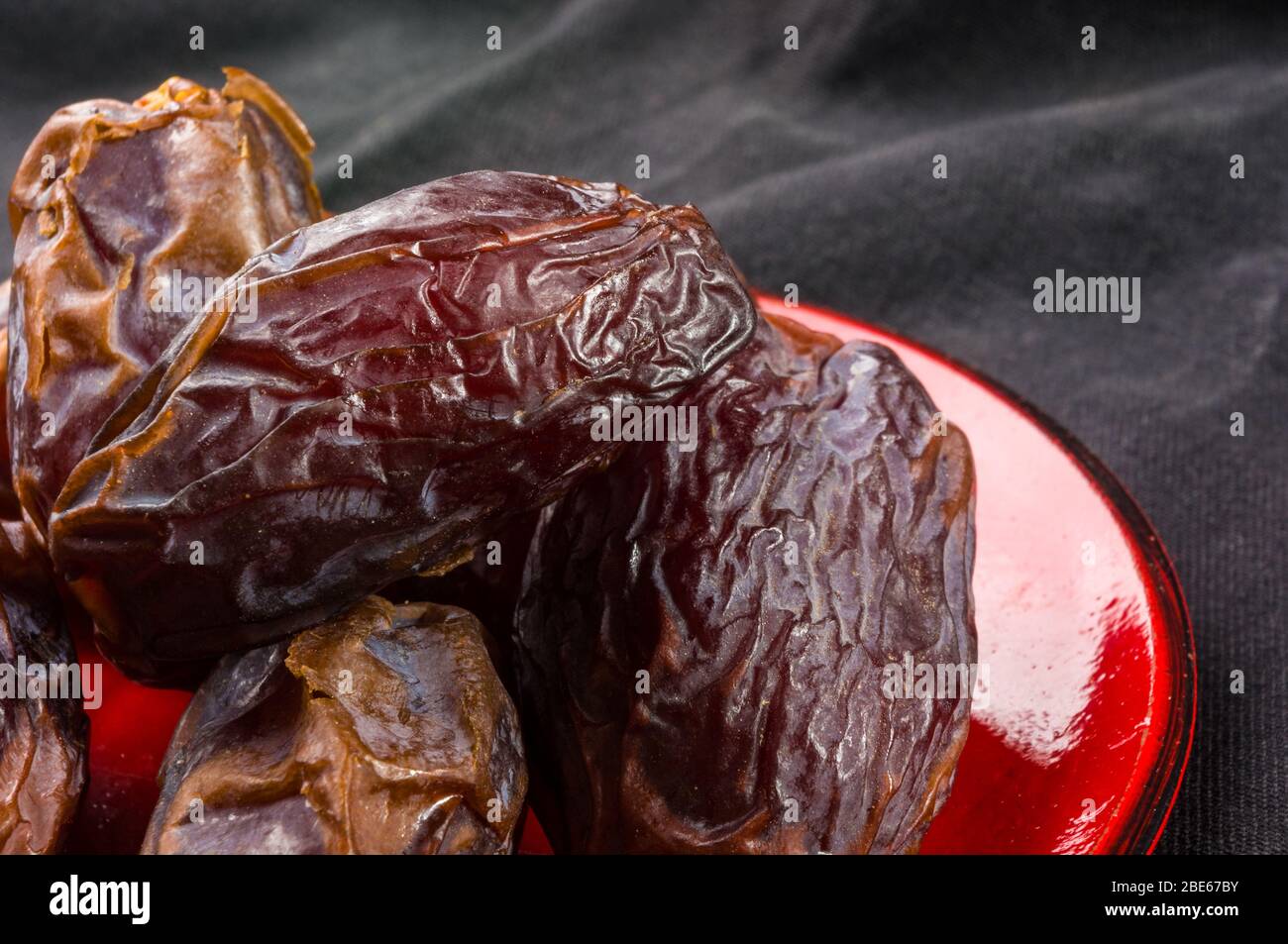 Big luxury dried date fruit in bowls on the dark surface, kurma ramadan