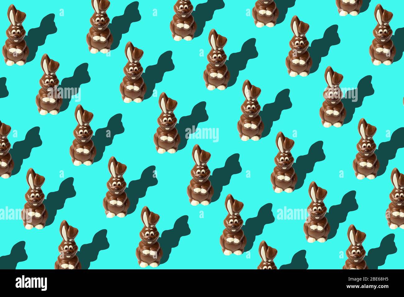 Trendy Easter pattern made of chocolate rabbits on blue background in ...
