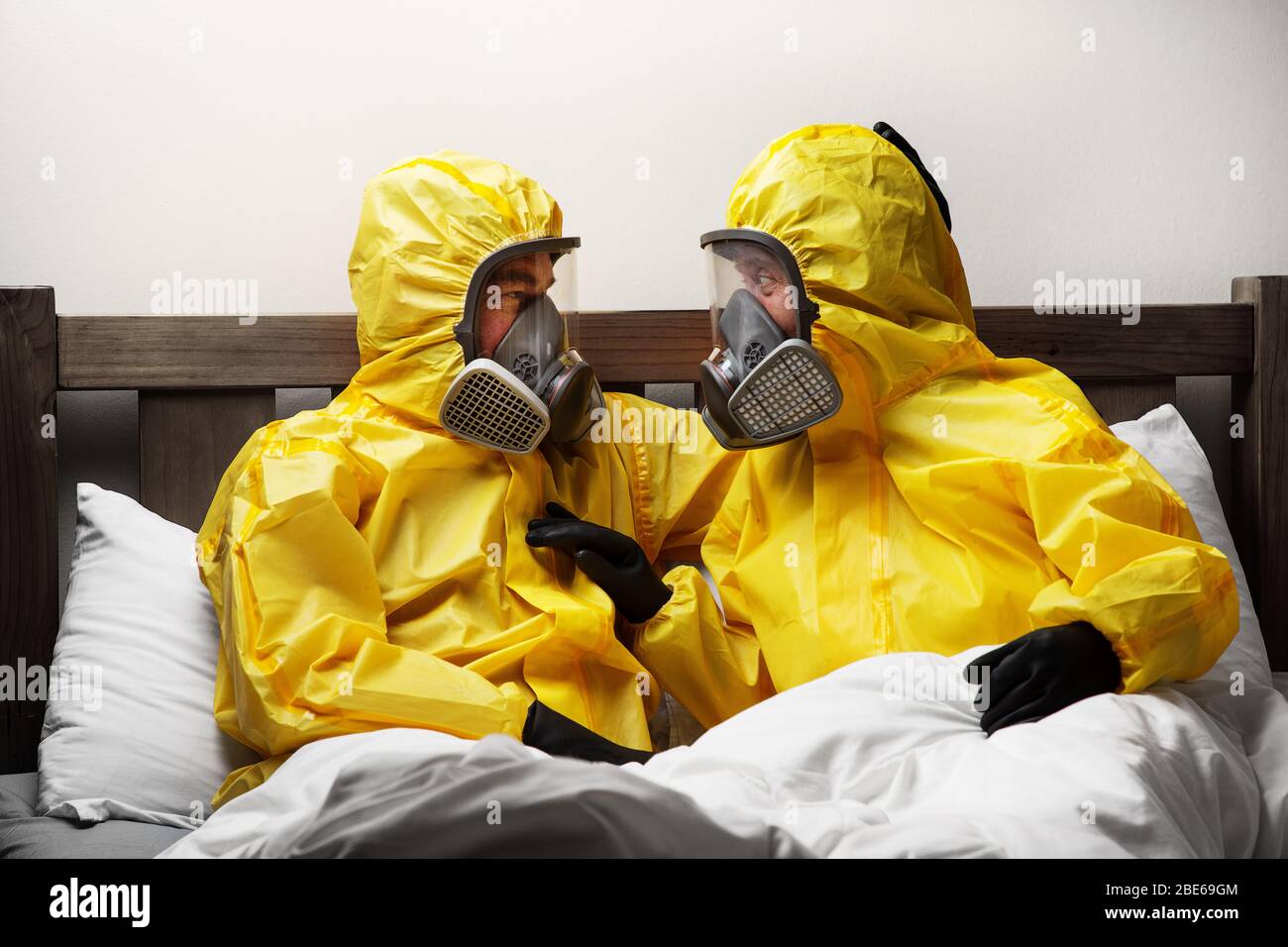 two people self isolating in bed being extra careful and wearing hazmat suit  Stock Photo - Alamy
