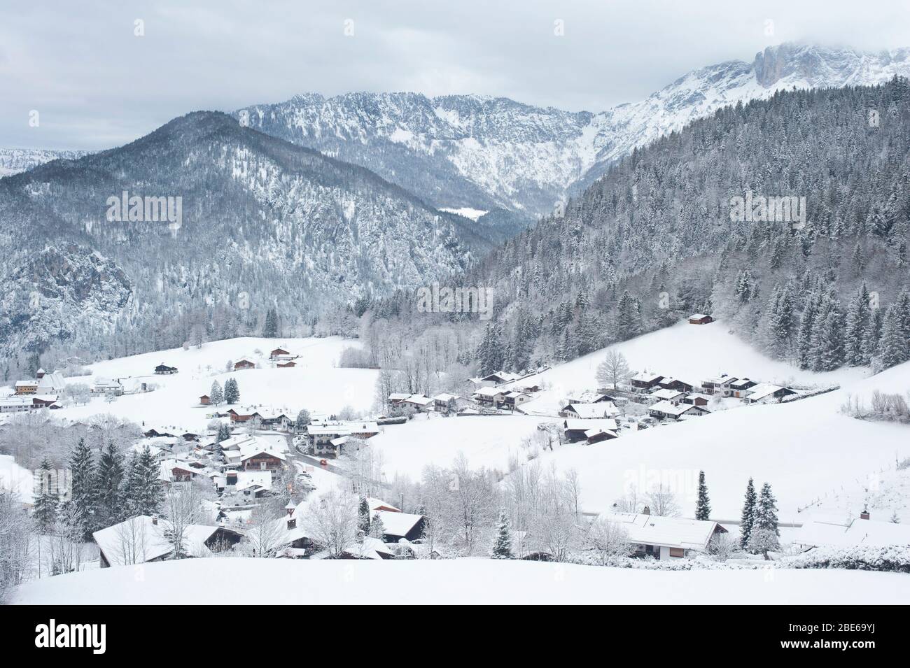 Village surrounded by snow covered mountains and forest, Berchtesgaden, Germany,  Europe Stock Photo