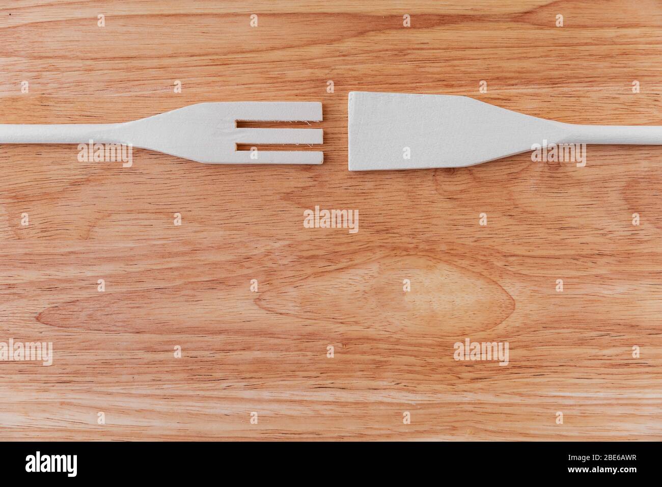 A white wooden spatula and a spatula with cloves lie opposite each ...