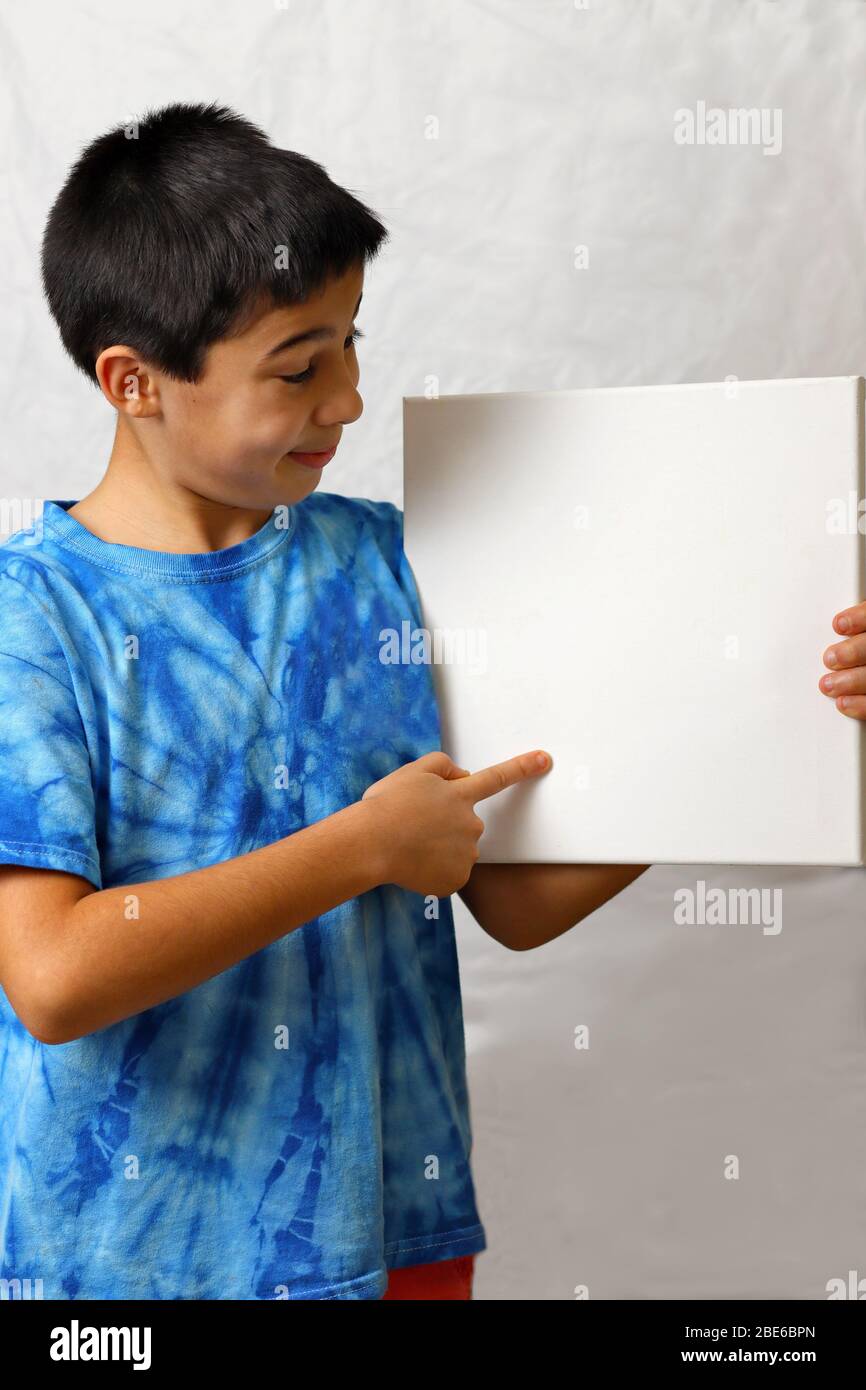 A boy holding a white board on a white background Stock Photo - Alamy